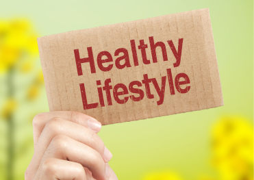 「自然の中で“Healthy Lifestyle”と書かれたボードを掲げる手。発酵食品や味噌を取り入れた健康的なライフスタイルを象徴するイメージ。」