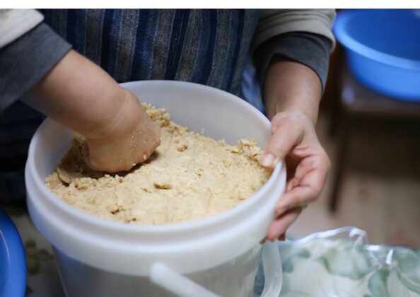 味噌を容器に詰めて表面を平らに整える工程｜発酵中の空気遮断とカビ防止のための仕上げ作業
