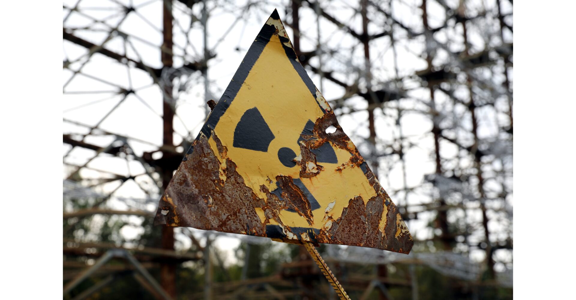 「放射線の危険を示す劣化した警告標識。放射性物質による環境リスクと健康への影響を象徴する」