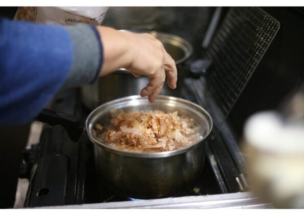 沸騰直前に昆布を取り出した後、鍋に鰹節を入れて一番出汁を取る工程。約1分静かに煮出して澄んだだしを仕上げる。